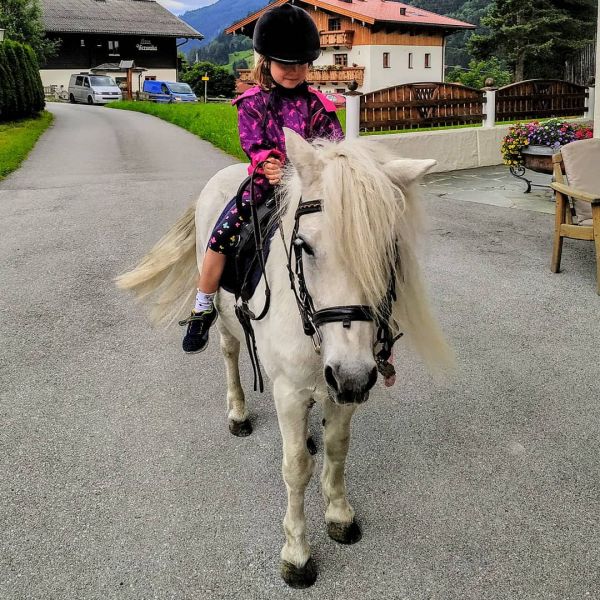 The kid is riding horses